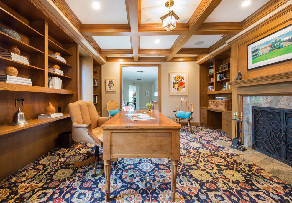 Photo of a traditional study room in San Diego with beige walls, carpet, a standard fireplace, a freestanding desk and multi-coloured floor.
