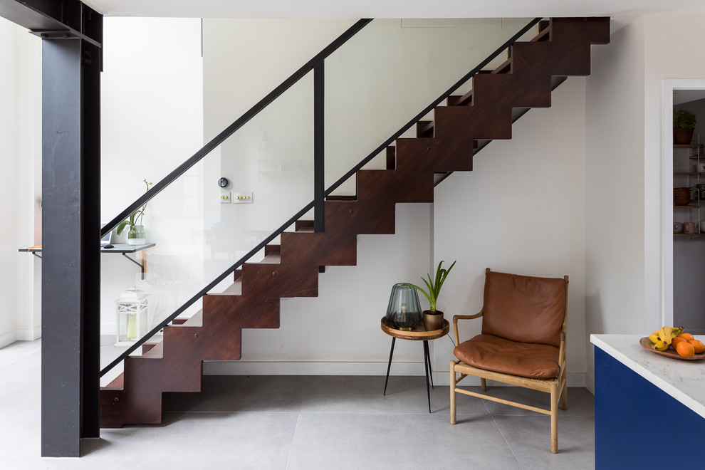 Design ideas for a contemporary wood straight staircase in London with wood risers and mixed railing.