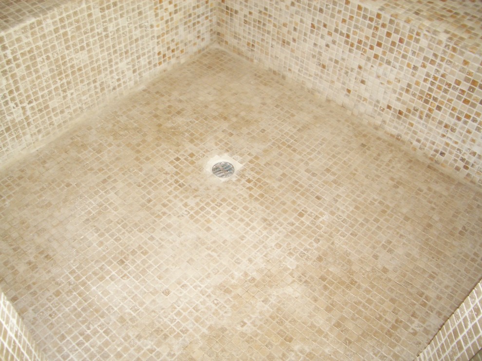 Photo of a small mediterranean 3/4 bathroom in Los Angeles with raised-panel cabinets, dark wood cabinets, a drop-in tub, an alcove shower, a one-piece toilet, multi-coloured tile, stone tile, beige walls, travertine floors, a drop-in sink, concrete benchtops, multi-coloured floor, a hinged shower door and beige benchtops.