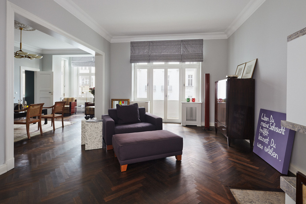 This is an example of a large contemporary open concept living room in Berlin with grey walls and dark hardwood floors.