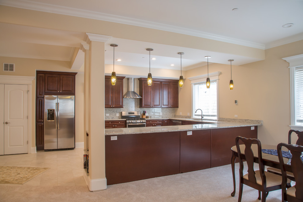 Inspiration for a large transitional u-shaped eat-in kitchen remodel in Chicago with shaker cabinets, dark wood cabinets, granite countertops, multicolored backsplash and stainless steel appliances