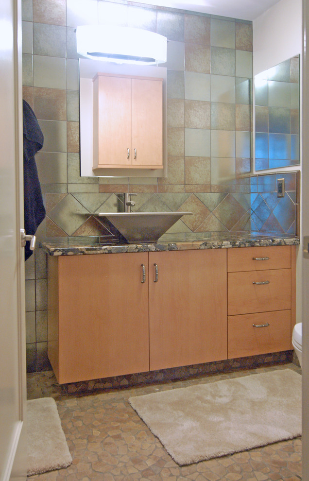 This is an example of a small contemporary 3/4 bathroom in San Luis Obispo with a vessel sink, flat-panel cabinets, light wood cabinets, granite benchtops, an alcove shower, a two-piece toilet, green tile, glass tile, white walls and linoleum floors.