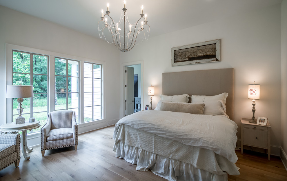 Inspiration for a large country master bedroom in New Orleans with light hardwood floors.