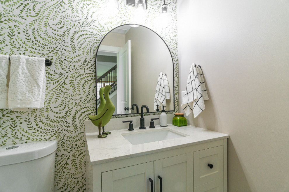 Foto på ett litet vit badrum, med skåp i shakerstil, vita skåp, en toalettstol med hel cisternkåpa, beige väggar, laminatgolv, marmorbänkskiva och brunt golv