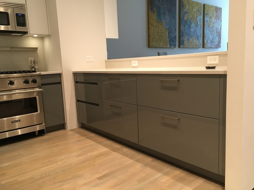 Photo of a small contemporary u-shaped eat-in kitchen in New York with flat-panel cabinets.