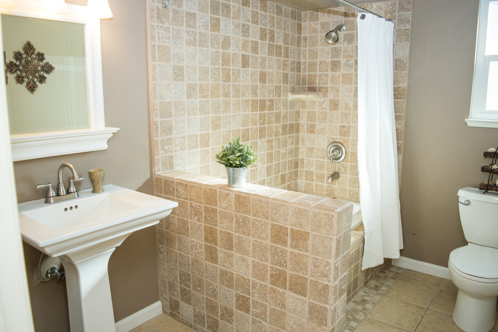 Example of a mid-sized classic master beige tile beige floor corner shower design in Sacramento with furniture-like cabinets, white cabinets, a one-piece toilet, beige walls and a pedestal sink