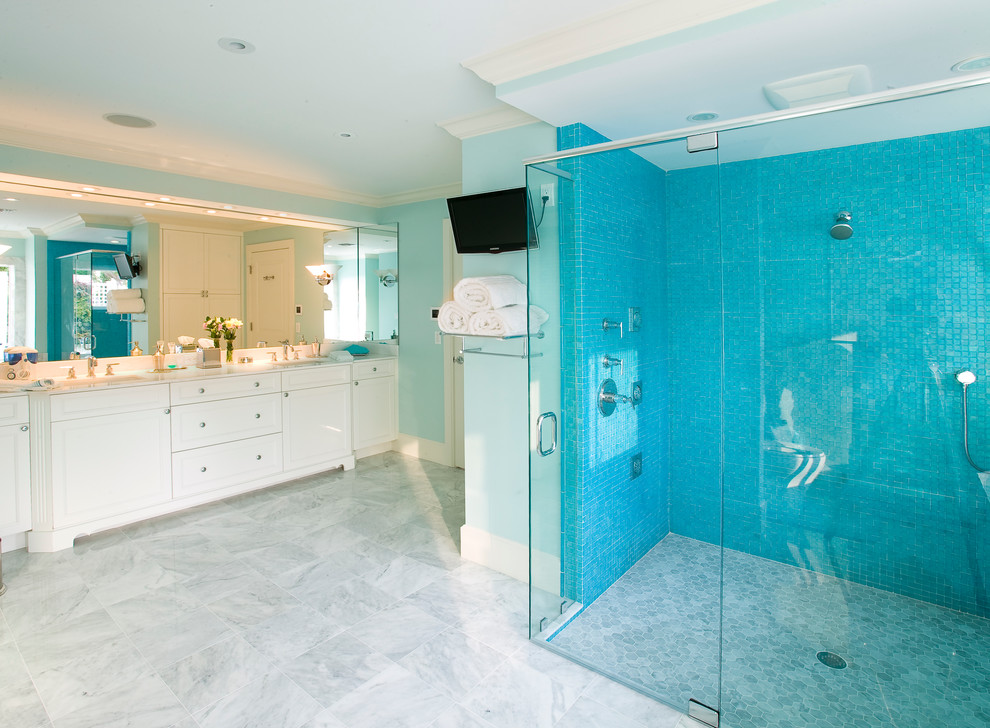 Large contemporary master bathroom in Tampa with recessed-panel cabinets, white cabinets, a drop-in tub, an alcove shower, blue tile, mosaic tile, blue walls, marble floors, an undermount sink and solid surface benchtops.