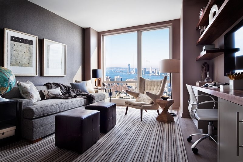 This is an example of a mid-sized modern study room in Boston with dark hardwood floors, a built-in desk and black walls.