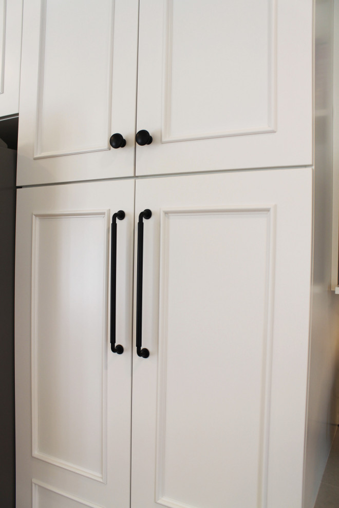Mid-sized transitional u-shaped medium tone wood floor eat-in kitchen photo in Seattle with an undermount sink, shaker cabinets, white cabinets, quartz countertops, white backsplash, ceramic backsplash, stainless steel appliances, a peninsula and gray countertops