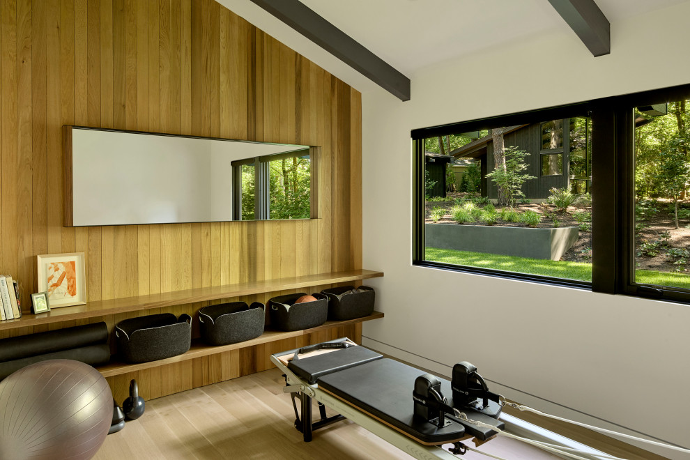 Inspiration for a midcentury multi-use home gym in Portland with light hardwood flooring and exposed beams.