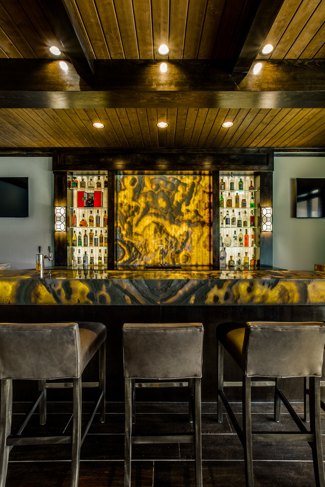 This is an example of an expansive contemporary u-shaped seated home bar in Dallas with an undermount sink, open cabinets, dark wood cabinets, onyx benchtops, yellow splashback, stone slab splashback and dark hardwood floors.