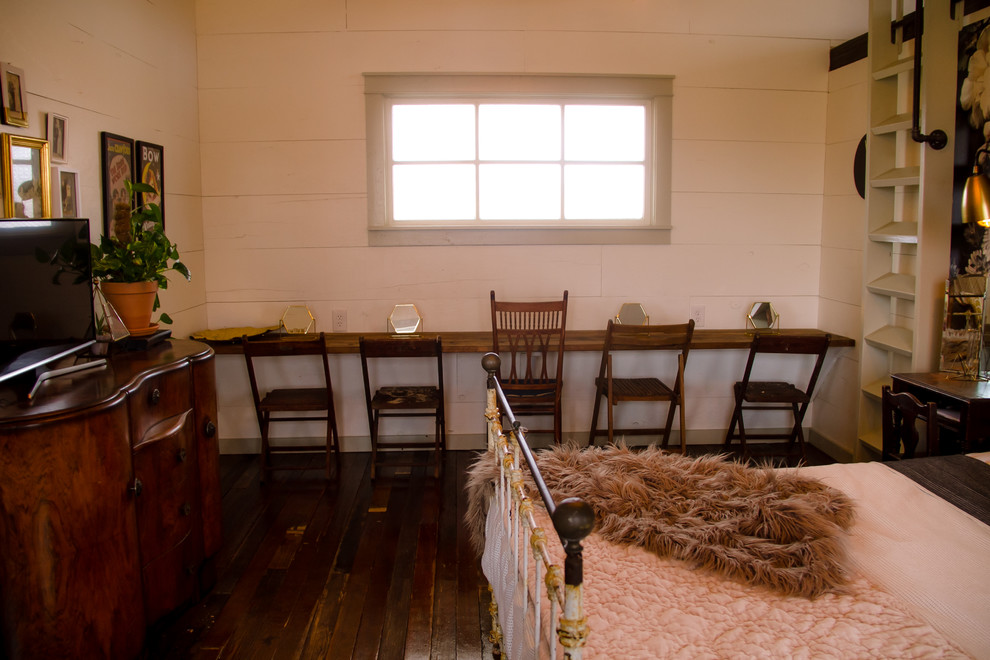 Großes Landhaus Hauptschlafzimmer mit weißer Wandfarbe, dunklem Holzboden und braunem Boden in Austin
