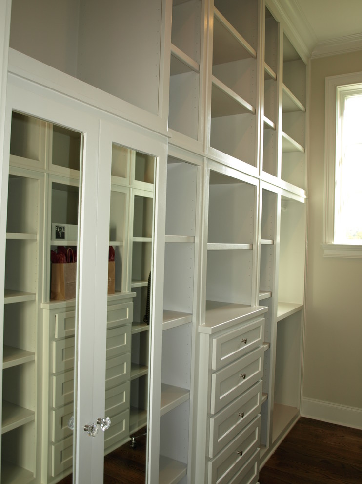 Design ideas for a country gender-neutral walk-in wardrobe in Nashville with shaker cabinets, white cabinets and dark hardwood floors.