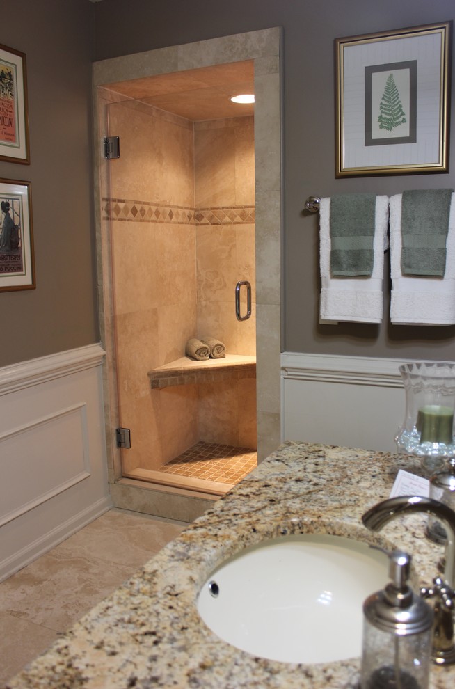 Example of a transitional beige tile and stone tile travertine floor bathroom design with an undermount sink, raised-panel cabinets, medium tone wood cabinets, granite countertops and brown walls