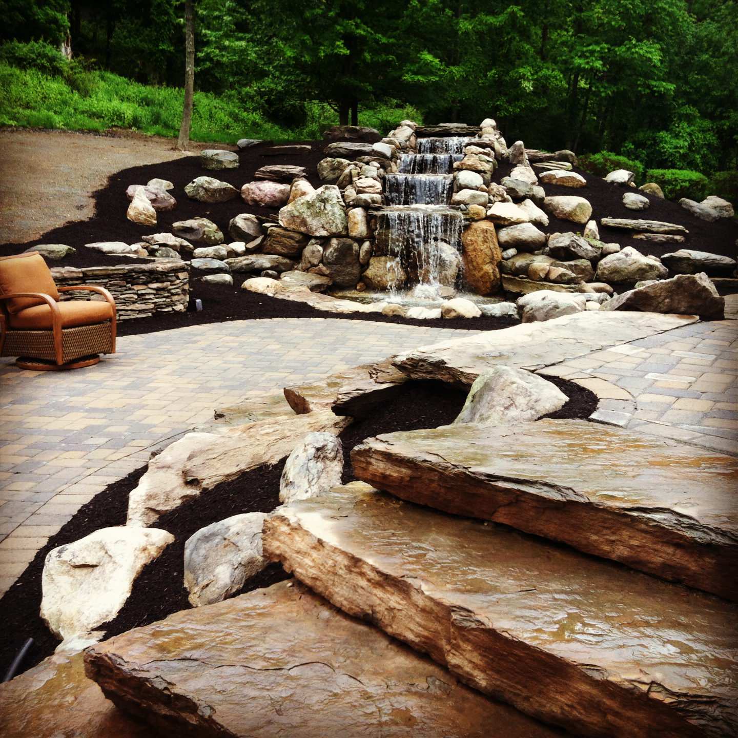 waterfall natural fieldstone walls with two tiered paver patio