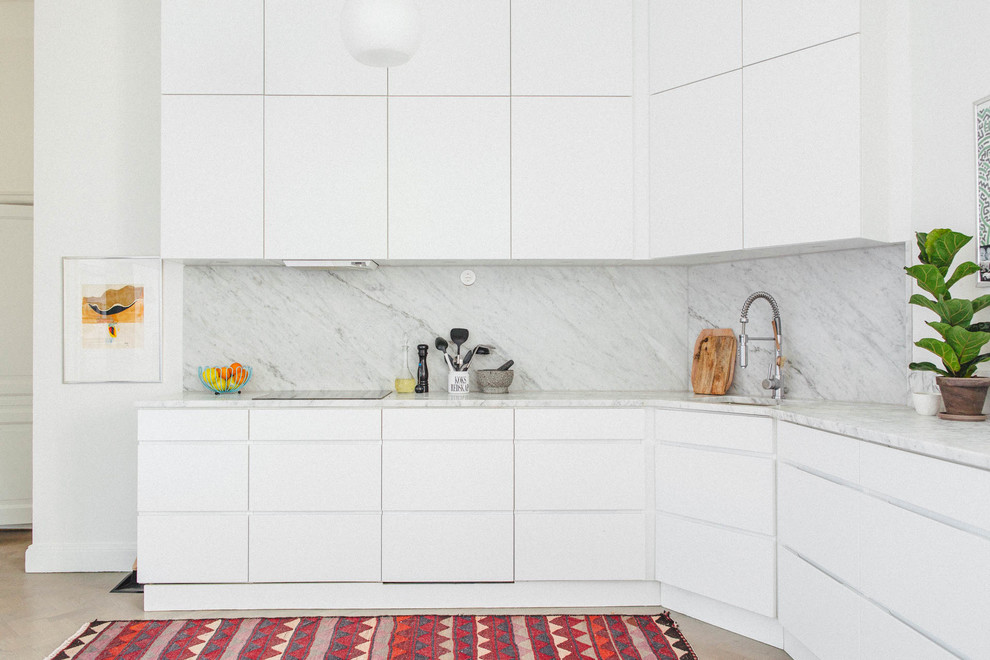 Photo of a mid-sized scandinavian l-shaped kitchen in Stockholm with flat-panel cabinets, white cabinets, an undermount sink, white splashback, light hardwood floors and no island.