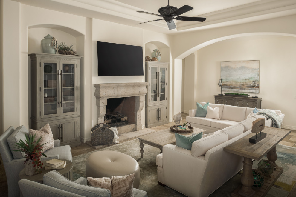 Design ideas for a mediterranean family room in Phoenix with terra-cotta floors, a standard fireplace, a stone fireplace surround, beige floor and coffered.