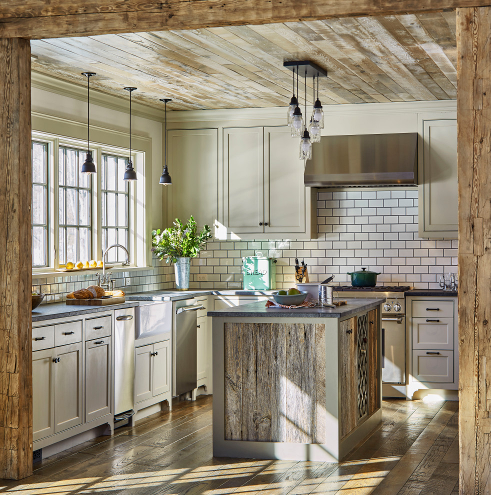 Design ideas for a country u-shaped separate kitchen in Boston with a farmhouse sink, beaded inset cabinets, grey cabinets, white splashback, subway tile splashback, stainless steel appliances, dark hardwood floors, with island, brown floor, black benchtop and wood.