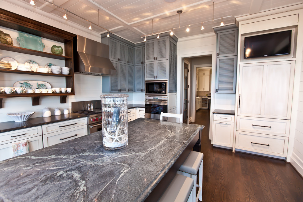 Beach style kitchen in Raleigh with louvered cabinets, grey cabinets, soapstone benchtops and panelled appliances.