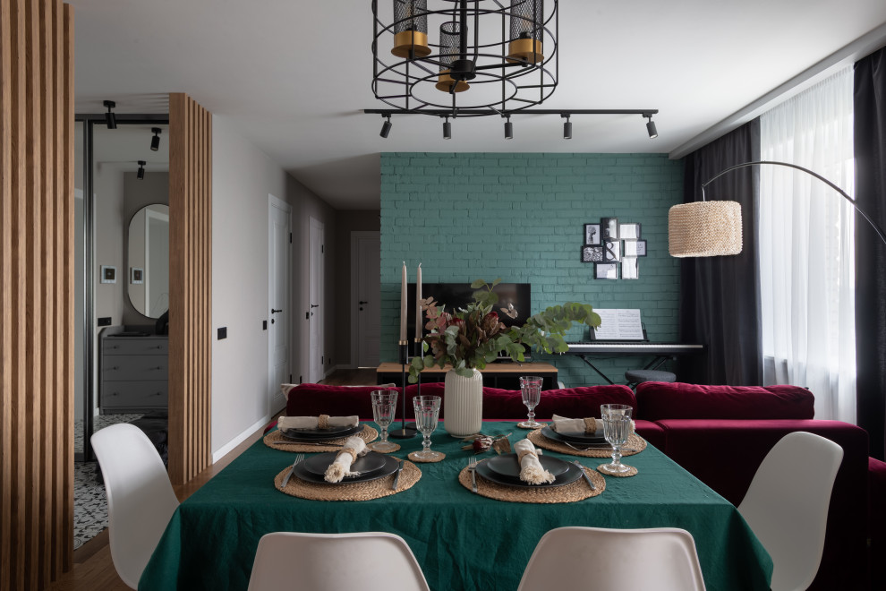 Dining room - small medium tone wood floor and brick wall dining room idea in Moscow with green walls