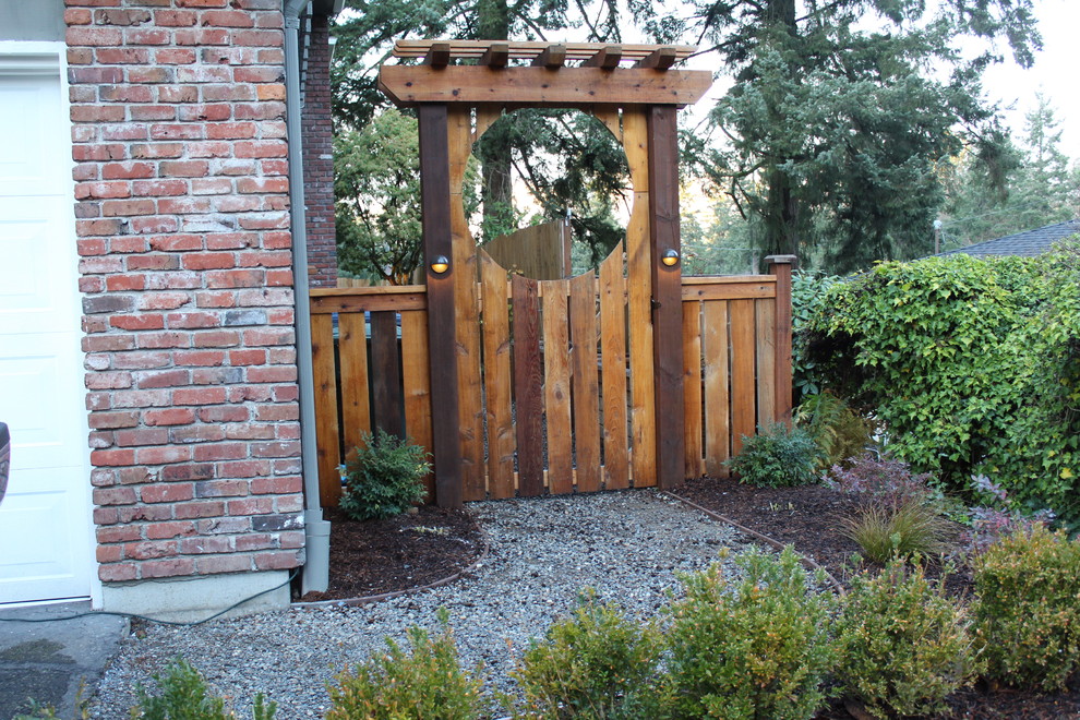 Photo of a mid-sized arts and crafts backyard full sun xeriscape for fall in Seattle with a garden path and decking.