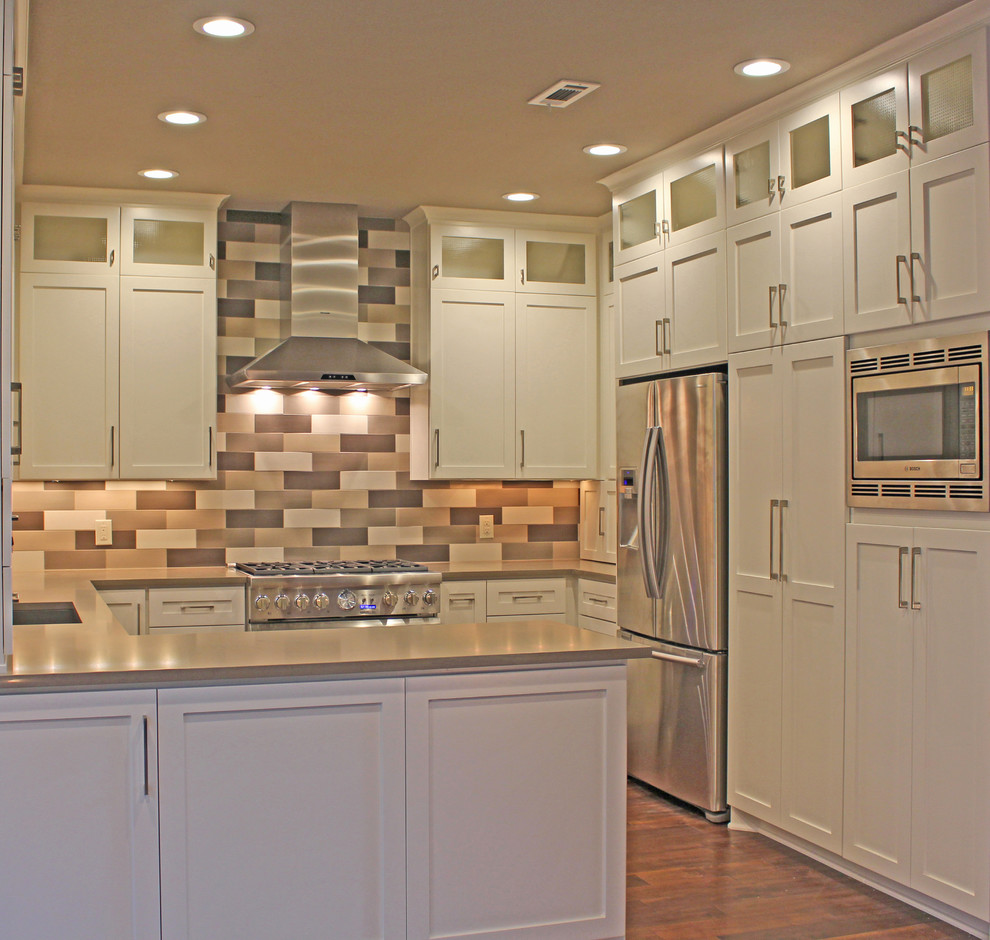 Inspiration for a mid-sized transitional u-shaped medium tone wood floor eat-in kitchen remodel in Austin with no island, shaker cabinets, white cabinets, quartz countertops, gray backsplash, ceramic backsplash, stainless steel appliances and an undermount sink