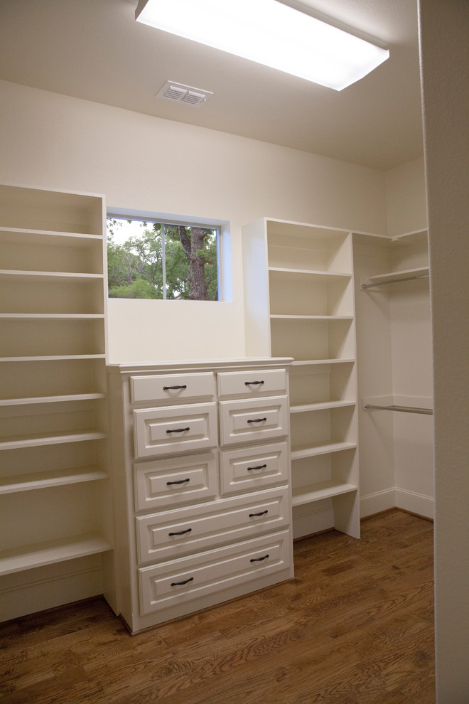 Large mediterranean men's walk-in wardrobe in Dallas with raised-panel cabinets, white cabinets and carpet.
