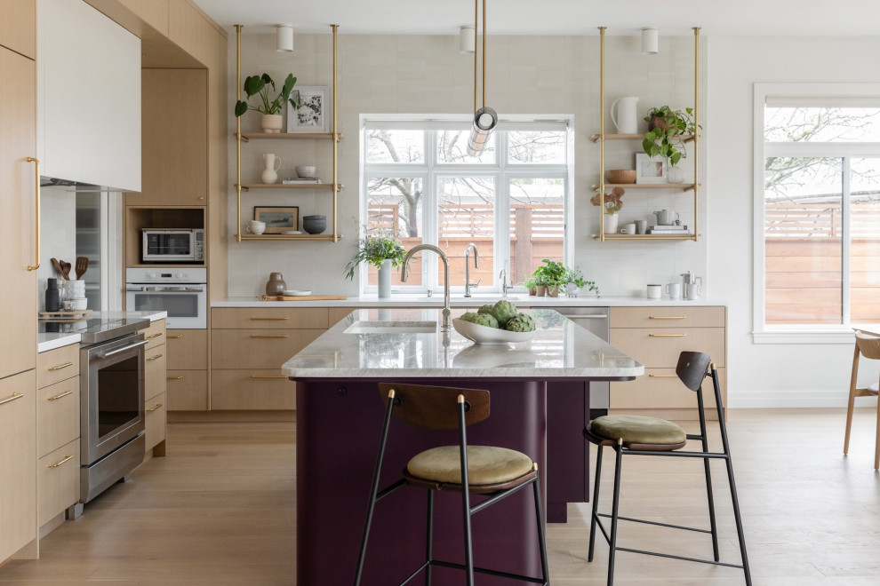 This is an example of a mid-sized contemporary l-shaped eat-in kitchen in San Francisco with an undermount sink, flat-panel cabinets, light wood cabinets, quartzite benchtops, white splashback, ceramic splashback, panelled appliances, light hardwood floors, with island, brown floor and beige benchtop.