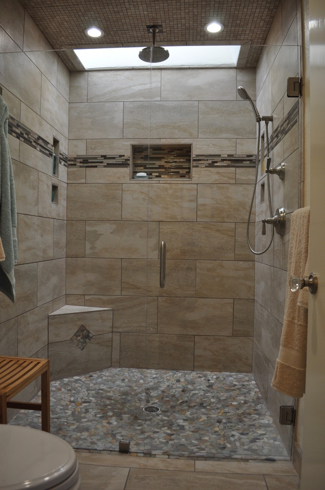 Inspiration for a mid-sized contemporary master bathroom in Sacramento with an alcove shower, beige tile, black tile, brown tile, gray tile, multi-coloured tile, pebble tile, a one-piece toilet, beige walls, ceramic floors and a hinged shower door.