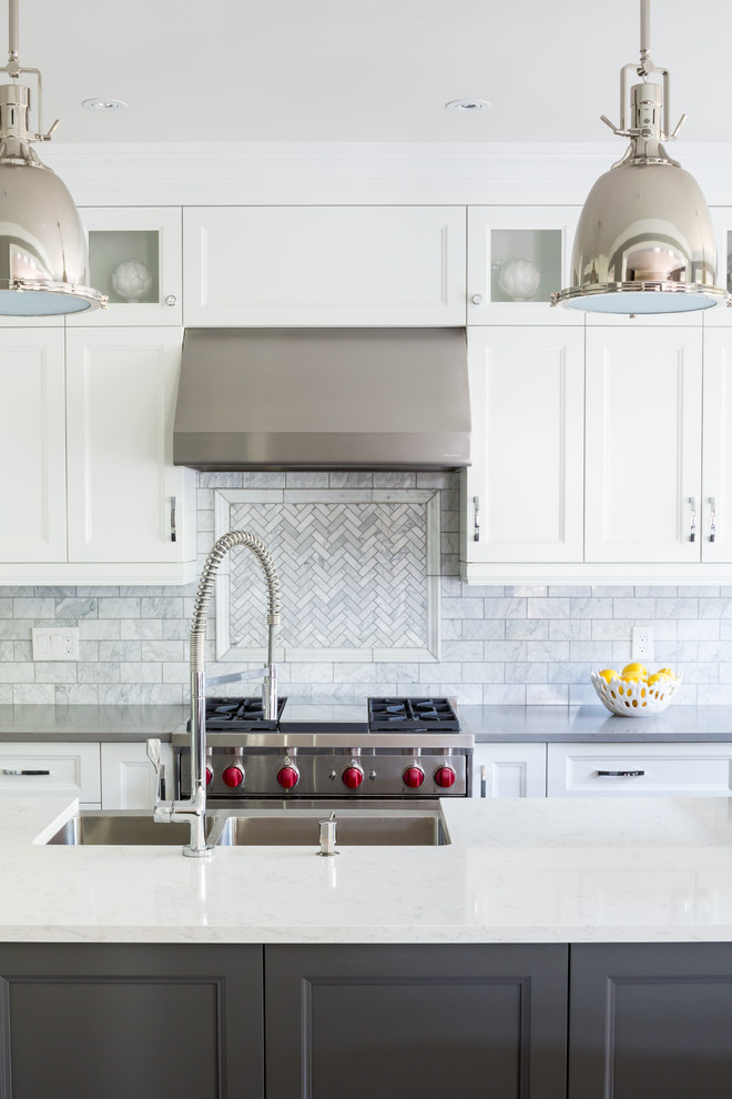 Large transitional l-shaped eat-in kitchen in Toronto with a farmhouse sink, recessed-panel cabinets, grey cabinets, quartz benchtops, grey splashback, stone tile splashback, stainless steel appliances, ceramic floors and with island.