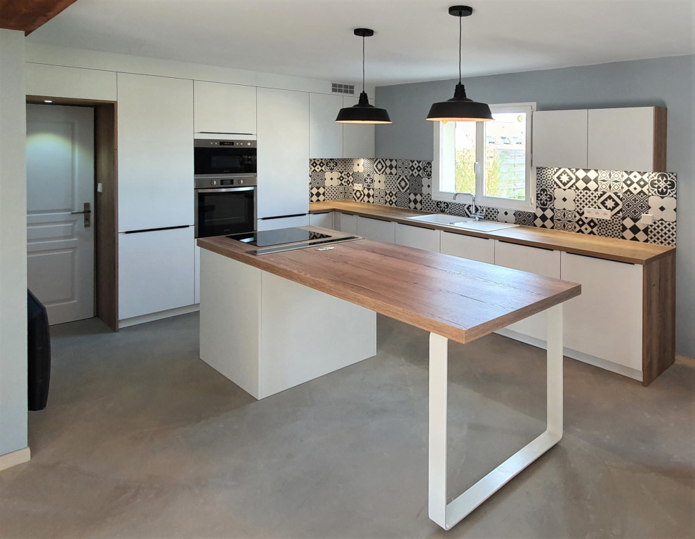Idéer för ett stort modernt brun kök, med en undermonterad diskho, släta luckor, vita skåp, träbänkskiva, grått stänkskydd, stänkskydd i cementkakel, integrerade vitvaror, betonggolv, en köksö och grått golv