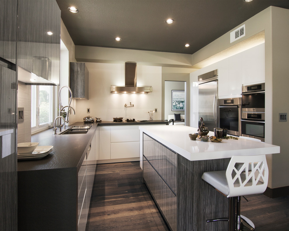 Inspiration for a contemporary u-shaped kitchen remodel in Los Angeles with an undermount sink, flat-panel cabinets, quartz countertops, white backsplash, porcelain backsplash, stainless steel appliances and white cabinets