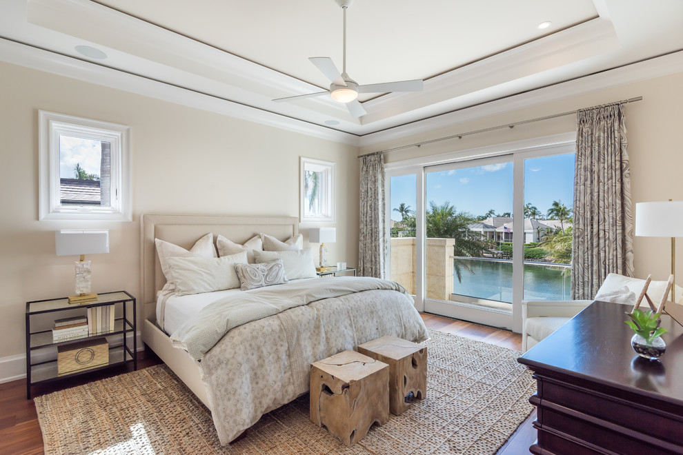 This is an example of a beach style bedroom in Miami with beige walls, medium hardwood floors and brown floor.