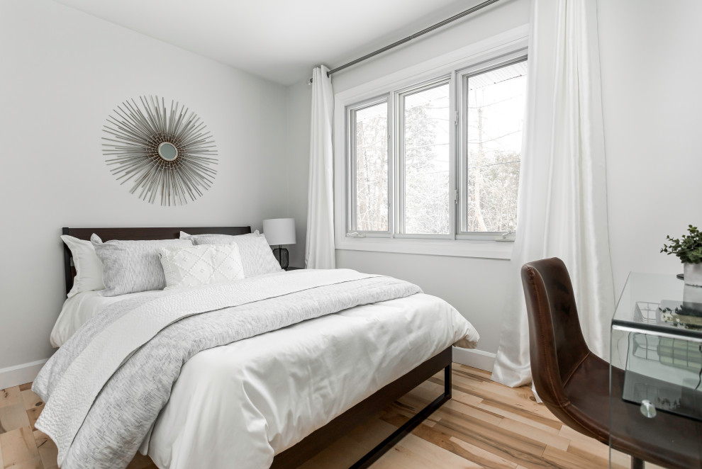 Kleines Landhausstil Gästezimmer mit weißer Wandfarbe, hellem Holzboden und braunem Boden in Montreal