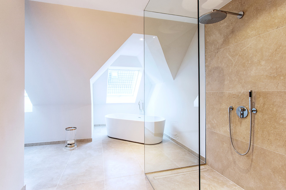 Photo of an expansive transitional bathroom in Hamburg with a freestanding tub, a curbless shower, beige tile, stone tile, white walls and limestone floors.