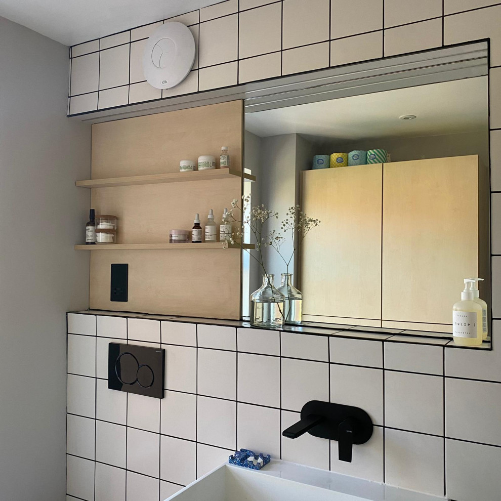 This is an example of a small scandinavian ensuite bathroom in Other with white cabinets, a corner shower, a wall mounted toilet, black and white tiles, ceramic tiles, grey walls, porcelain flooring, a wall-mounted sink, grey floors, a hinged door, a single sink and a floating vanity unit.