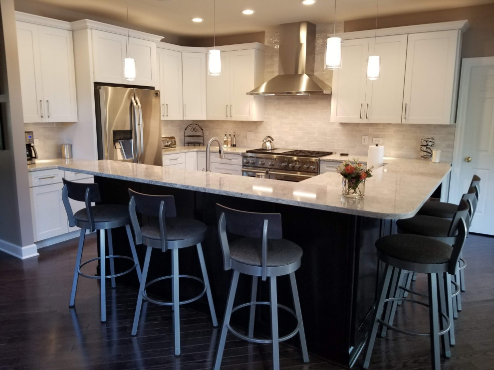 Example of a transitional l-shaped dark wood floor and brown floor kitchen design in Chicago with shaker cabinets, white cabinets, quartz countertops, stainless steel appliances and an island