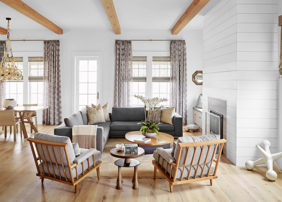 Beach Bungalow - Inspiration for a huge coastal open concept light wood floor and beige floor living room remodel in Houston with white walls, a standard fireplace, a wood fireplace surround and no tv