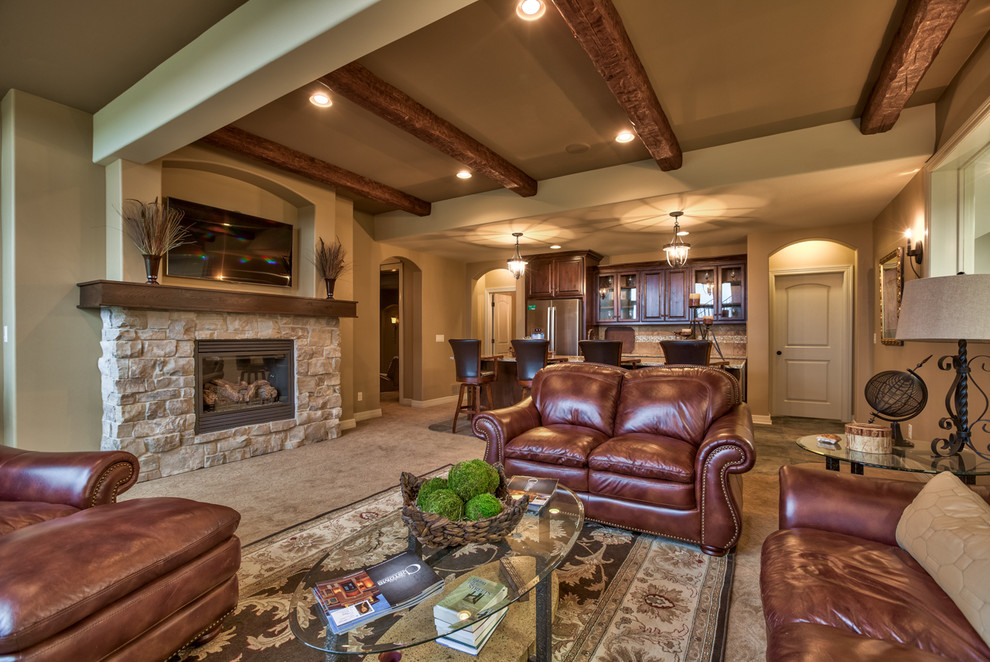Photo of a large mediterranean open concept living room in Omaha with beige walls, carpet, a standard fireplace, a stone fireplace surround and a wall-mounted tv.