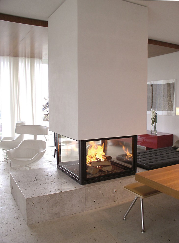 This is an example of an expansive contemporary formal open concept living room in Stuttgart with white walls, concrete floors, a two-sided fireplace, a plaster fireplace surround, no tv and grey floor.