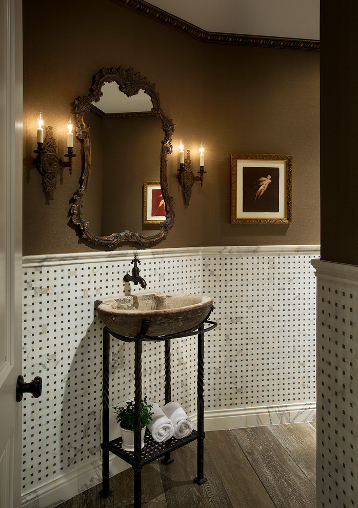 This is an example of a mid-sized mediterranean powder room in Phoenix with open cabinets, ceramic floors, brown walls and a vessel sink.