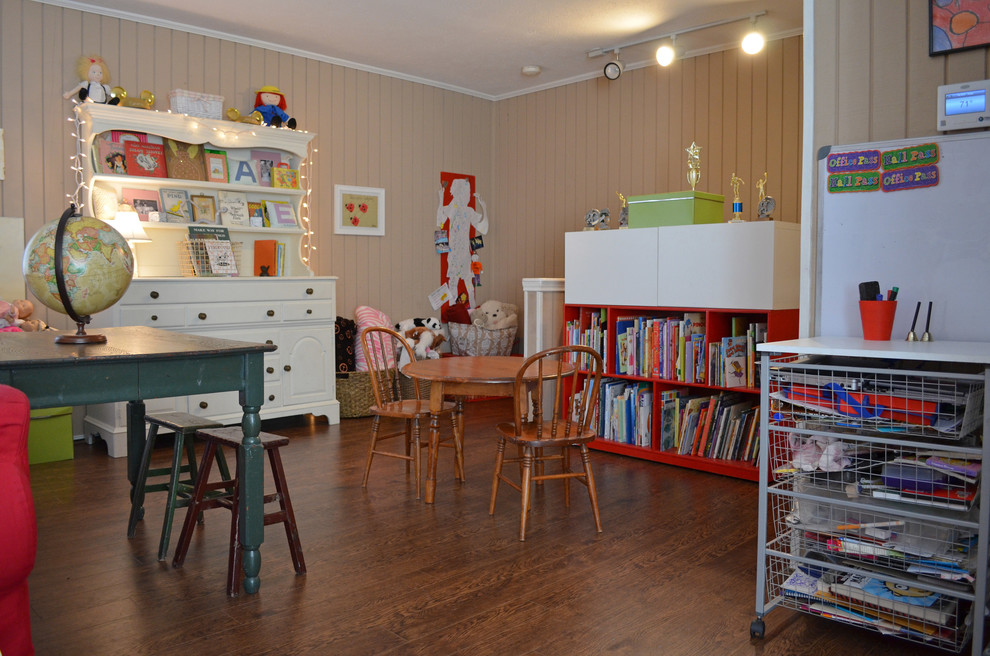 This is an example of a traditional gender-neutral kids' playroom for kids 4-10 years old in Dallas with beige walls and medium hardwood floors.