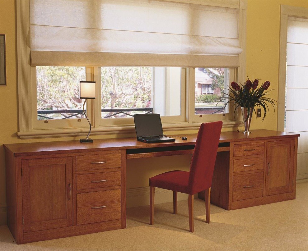 This is an example of a large traditional study room in Sydney with beige walls, carpet and a freestanding desk.