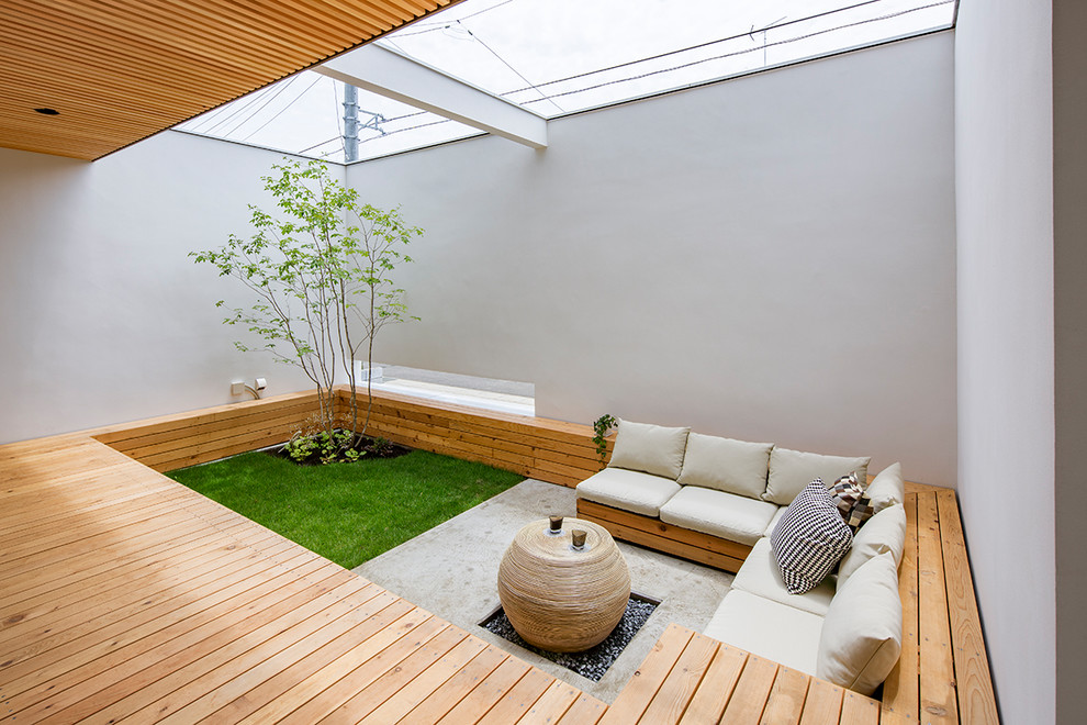 Asian courtyard patio in Other with a roof extension.