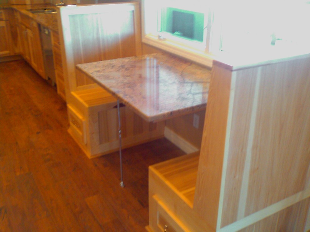 Example of a mid-sized mountain style u-shaped dark wood floor and brown floor eat-in kitchen design with shaker cabinets, medium tone wood cabinets, granite countertops, beige backsplash, ceramic backsplash, stainless steel appliances and two islands