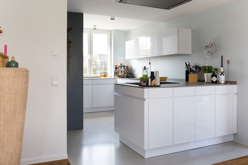 Offene, Kleine Moderne Küche in U-Form mit flächenbündigen Schrankfronten, weißen Schränken, Betonboden, Halbinsel, grauem Boden, brauner Arbeitsplatte, Waschbecken, Quarzwerkstein-Arbeitsplatte und Küchengeräten aus Edelstahl in Sonstige