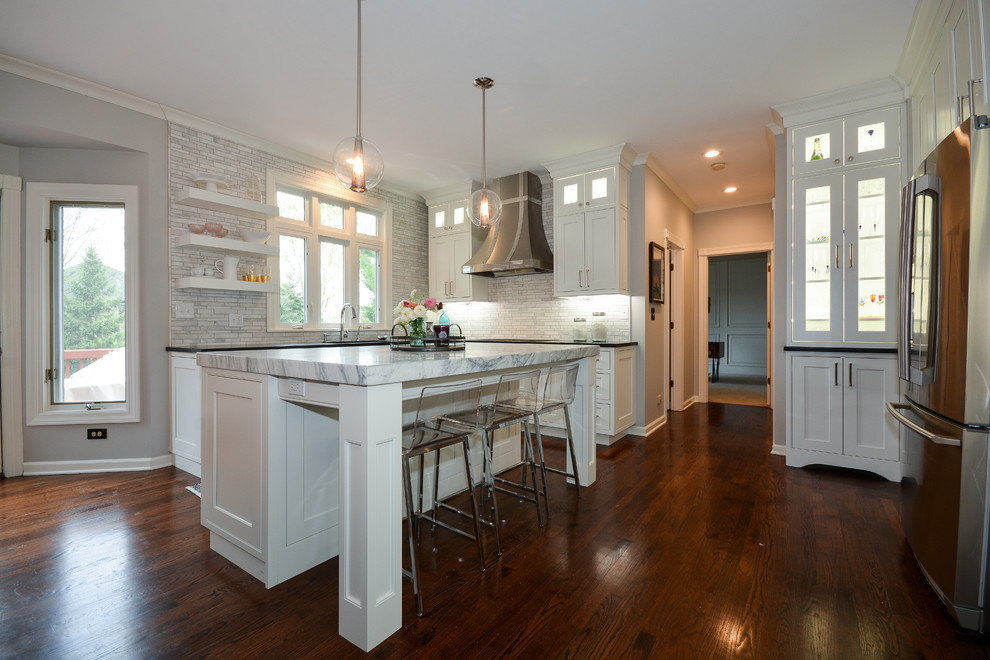 Inspiration for a large transitional u-shaped dark wood floor and brown floor eat-in kitchen remodel in Chicago with an undermount sink, recessed-panel cabinets, white cabinets, soapstone countertops, gray backsplash, marble backsplash, stainless steel appliances and an island