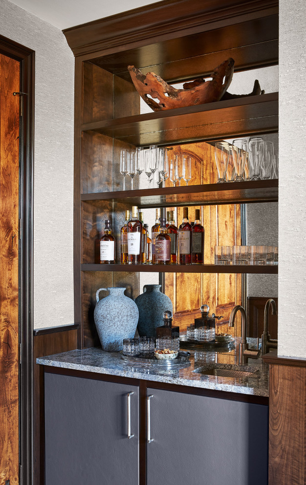Esempio di un piccolo angolo bar con lavandino chic con lavello sottopiano, ante lisce, ante grigie, top in granito, paraspruzzi con lastra di vetro, parquet scuro, pavimento marrone e top grigio