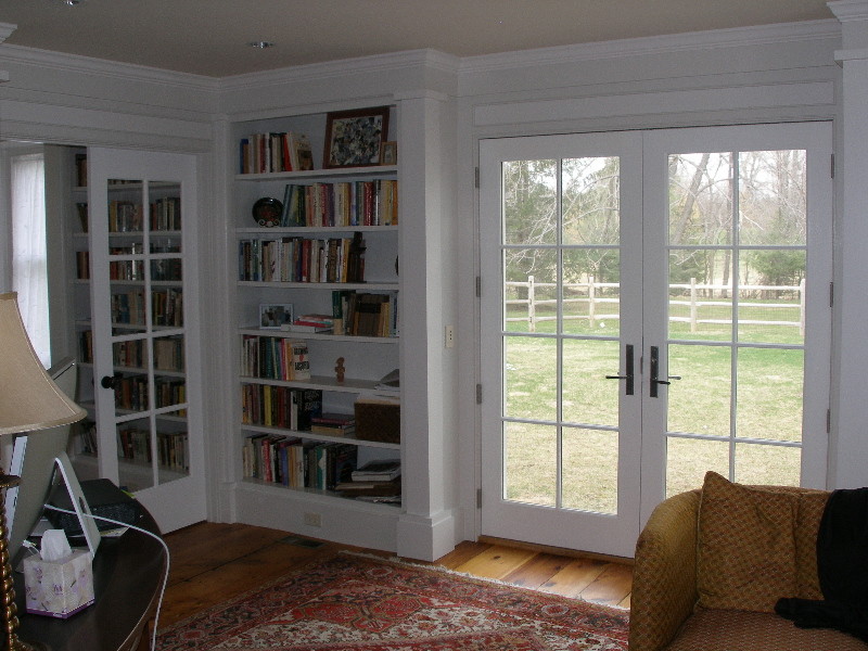 Inspiration for a mid-sized traditional open concept living room in Boston with a library, beige walls and medium hardwood floors.