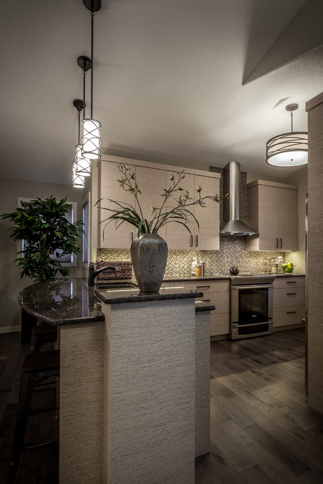 Example of a mid-sized minimalist u-shaped medium tone wood floor and gray floor enclosed kitchen design with a double-bowl sink, flat-panel cabinets, beige cabinets, granite countertops, multicolored backsplash, mosaic tile backsplash, stainless steel appliances and a peninsula